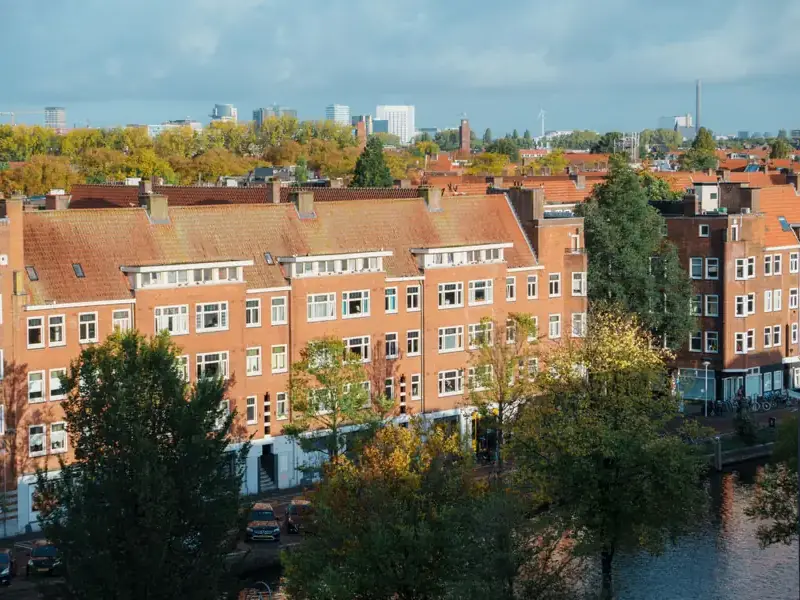 Woonblokken met oranje pannendaken, schoorstenen en dakkapellen, van bovenaf gezien - dakreparatie in Rotterdam